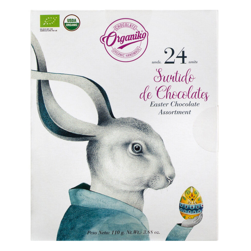 Ein Hase im Anzug hält ein dekoriertes Ei auf einer Schachtel mit der Aufschrift "Mini-Schokoladentafeln Bio in Osterhasen Geschenkpackung, 110 g" von Chocolate Orgániko.
