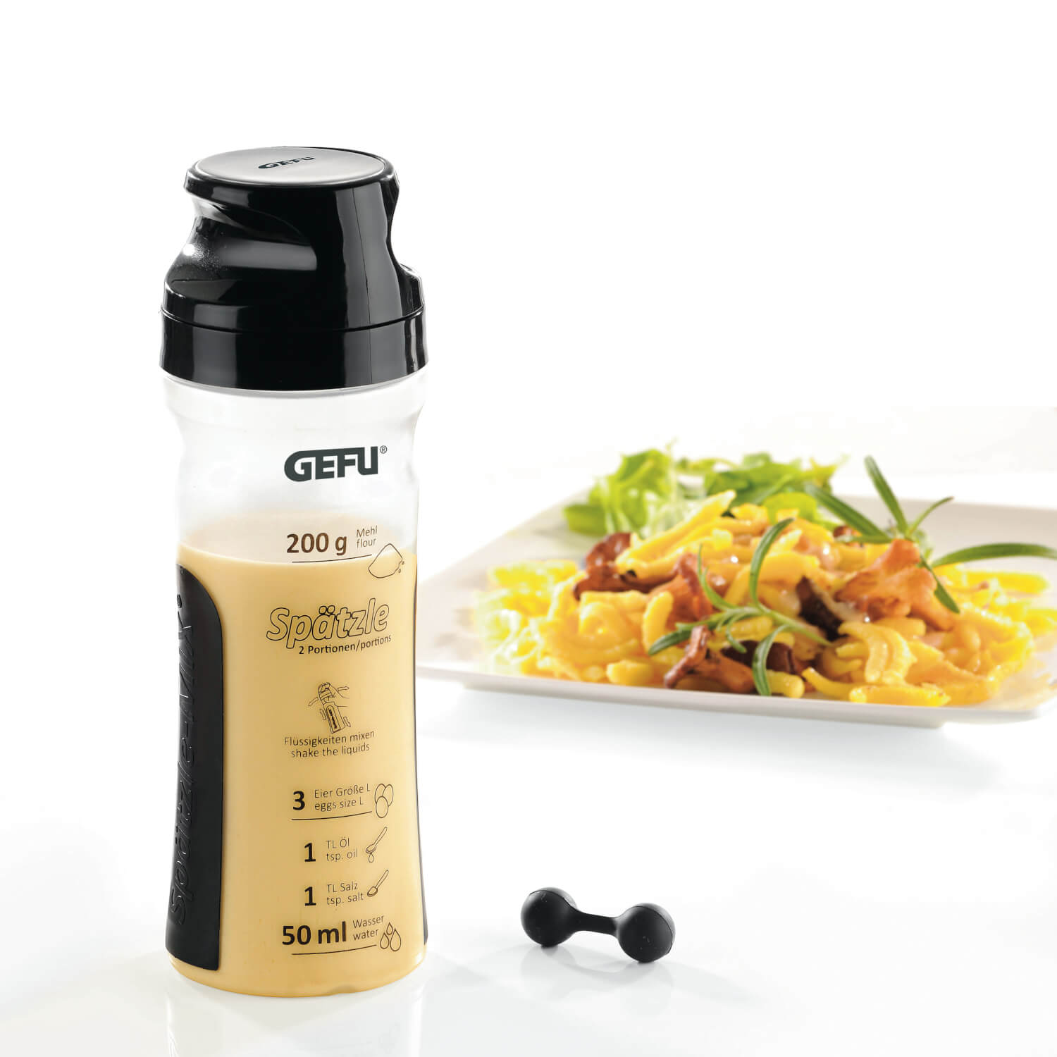 Eine Gefu Crêpes- & Spätzle-Mix Twister Flasche mit Teig steht neben einem Teller mit gekochten Spätzle und Salat.
