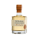 Eine 250-ml-Flasche Remodena Weißer Balsamico aus Modena IGP Bio mit orangefarbenem Verschluss und Etikett.