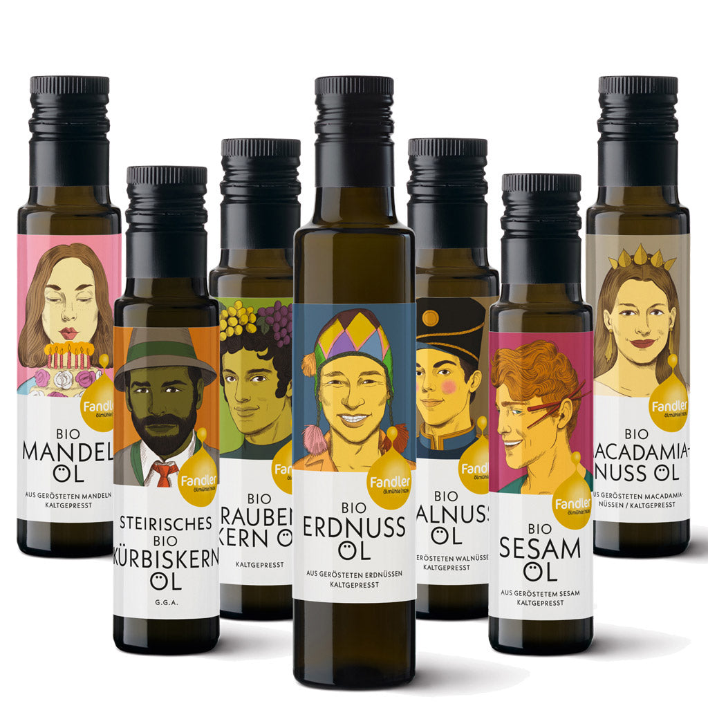 Sieben Flaschen des 7er Nuss- & Kernöl Probierpakets der Ölmühle Robert Fandler sind vor weißem Hintergrund gruppiert und zeigen jeweils illustrierte Personen auf den Etiketten.